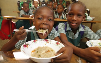 Dječak jede kašu, drugi se smješka