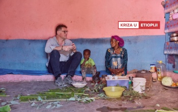 Magnus sjedi i razgovara sa ženom iz Etiopije, između njih sjedi dijete