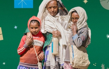 Otac i dvoje djece stoje zagrljeni