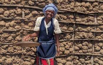 Nasmijana kuharica-volonterka drži poklopac od lonca u rukama