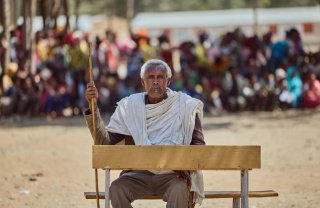 Starješina zajednice Beyne Bsrat sjedi na klupi ispred djece