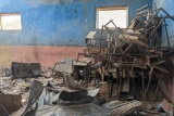 Stolovi i stolice nabacani na hrpu u uništenoj učionici