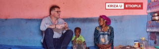 Magnus sjedi i razgovara sa ženom iz Etiopije, između njih sjedi dijete