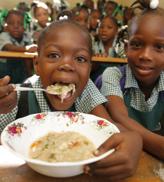 Dječak jede kašu, drugi se smješka