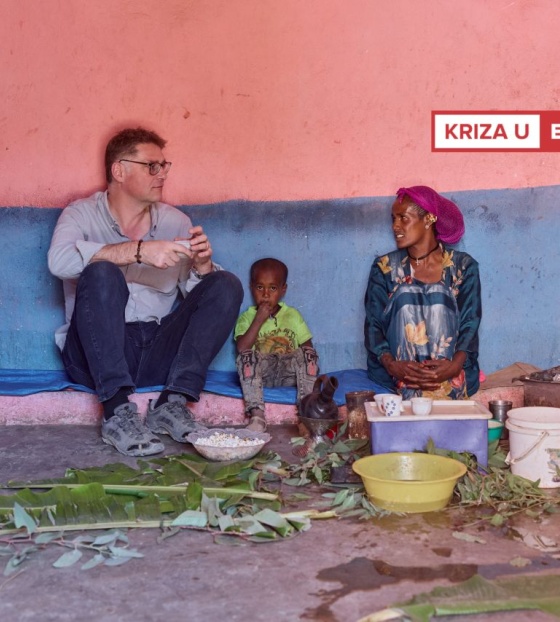 Magnus sjedi i razgovara sa ženom iz Etiopije, između njih sjedi dijete