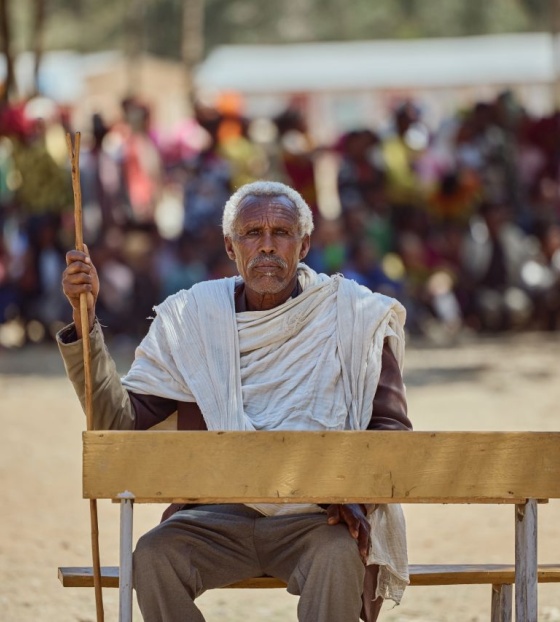 Starješina zajednice Beyne Bsrat sjedi na klupi ispred djece