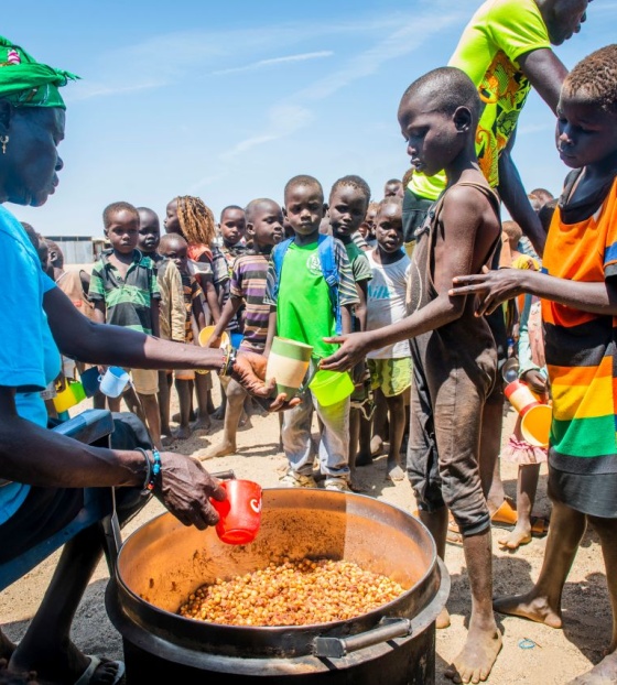 Kuharica dijeli obrok djeci koja čekaju u koloni