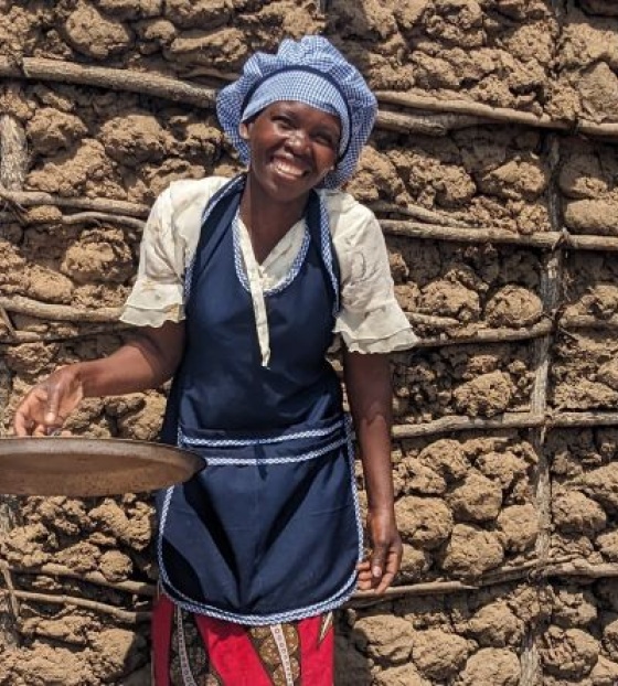 Nasmijana kuharica-volonterka drži poklopac od lonca u rukama