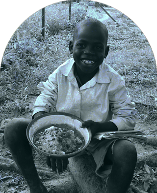 Dijete u Južnom Sudanu sjedi da jede u školi.