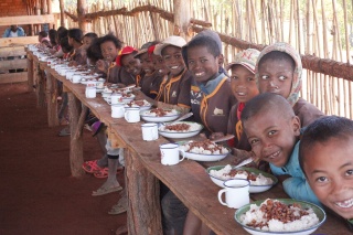 Djeca sjede za stolom s obrocima u svojim tanjurima